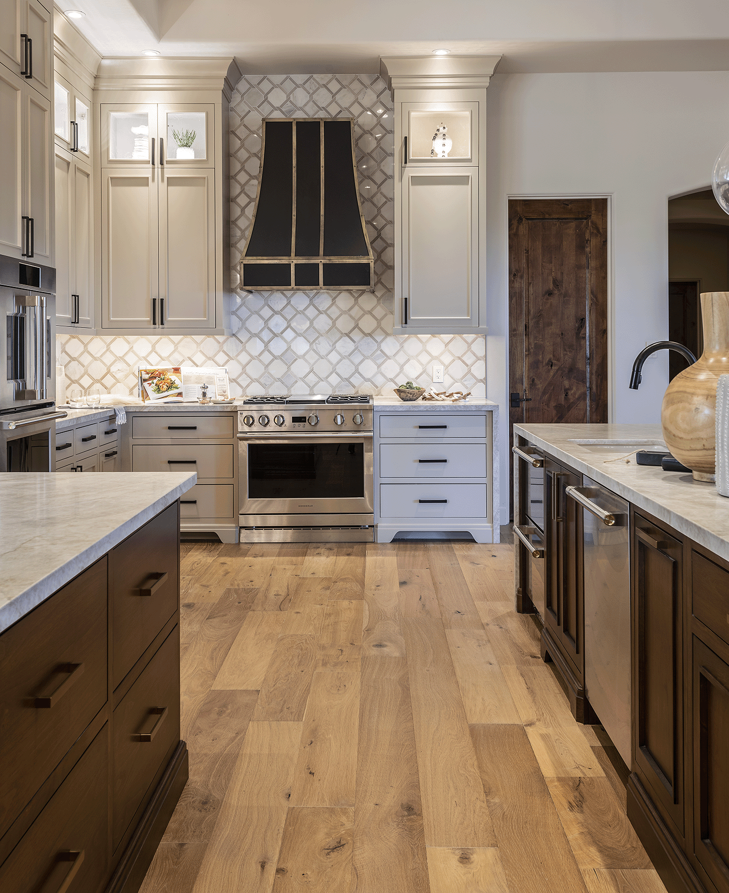 Neutral colored kitchen with beige and white, hardwood floors, stainless steel appliances.