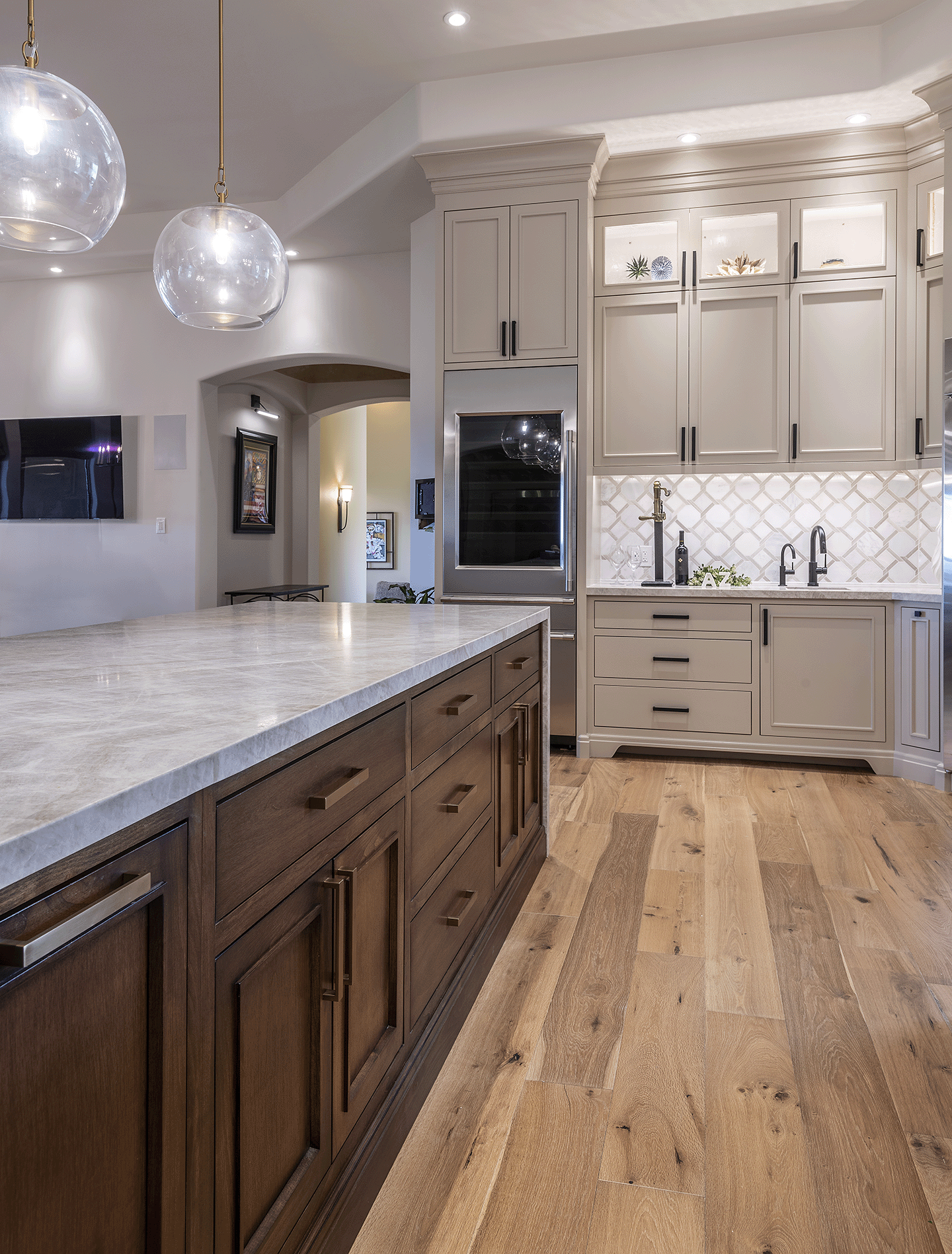 Neutral colored kitchen with beige and white, hardwood floors, stainless steel appliances.