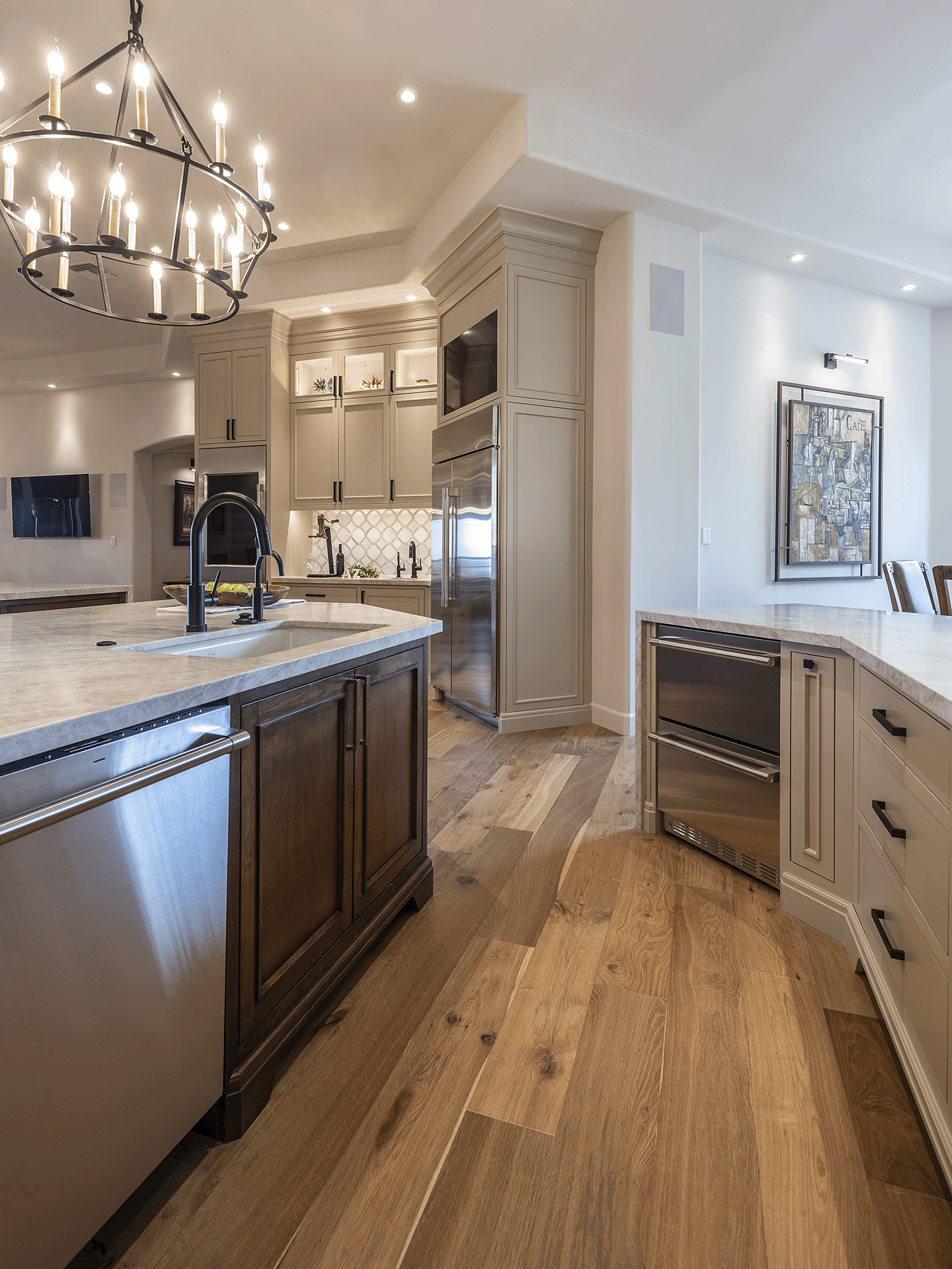 Neutral colored kitchen with beige and white, hardwood floors, stainless steel appliances.