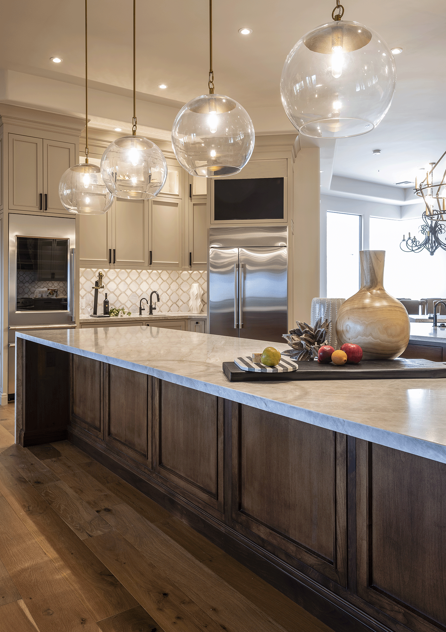 Kitchen island with marble counter, wood panels, hardwood floors.