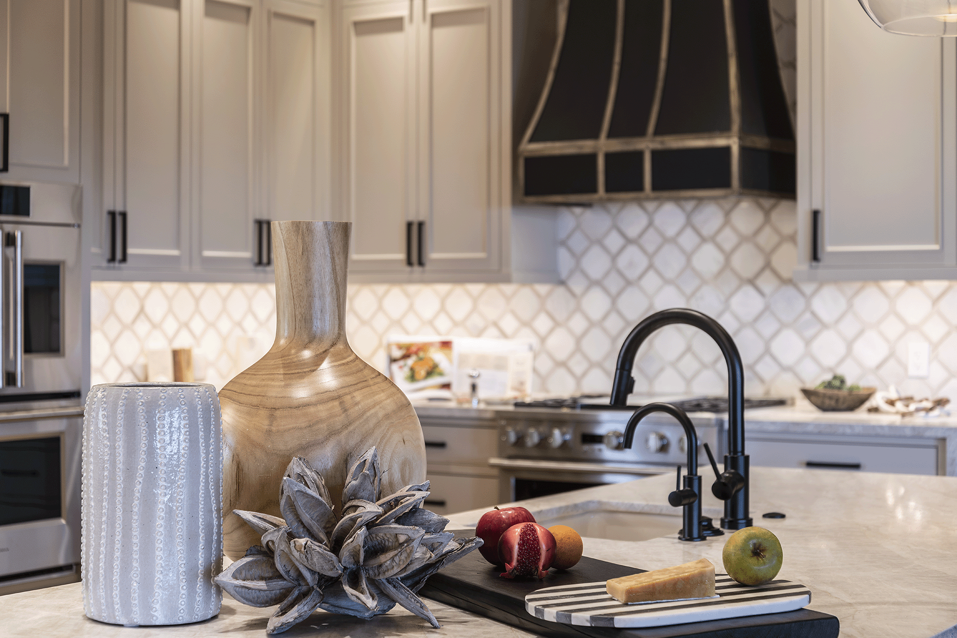 Neutral kitchen with beige and white walls, cabinets, and countertop, black appliances and accents.